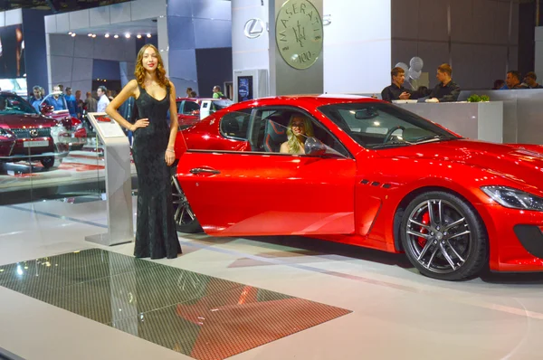 Mujeres jóvenes del equipo Maserati. Gran Turismo. Rojo coche Moscú Salón Internacional de Automóviles Premium — Foto de Stock