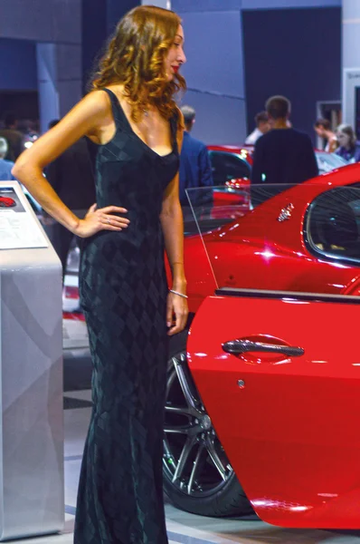 Jonge womens van Team Maserati. Gran Turismo. Rode auto kijken Moskou International Auto Salon — Stockfoto