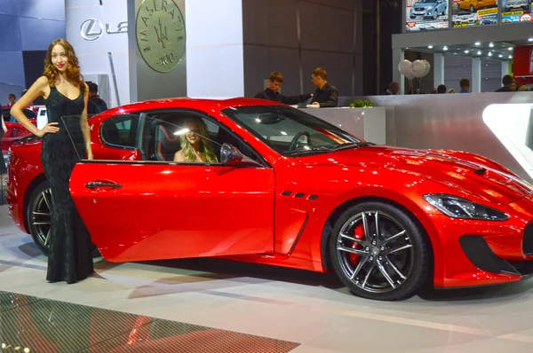 Takım Maserati genç kadınlardan. Gran Turismo. Kırmızı araba Moskova Uluslararası Otomobil Salon Parlatıcı