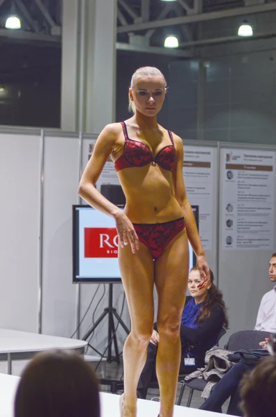 5ª Exposición Internacional de ropa interior, ropa de playa, ropa de hogar y calcetería Lingrie Expo Joven hermosa mujer morena en una lencería de encaje rojo y negro — Foto de Stock