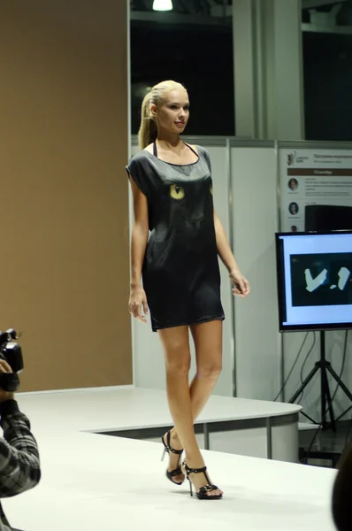 During the Show Lingrie Expo Moscow Autumn 5th International Exhibition of underwear, beachwear, home wear and hosiery Young beautiful blonde in a black nightgown with cat's eyes — Φωτογραφία Αρχείου