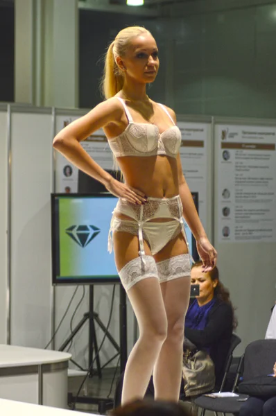 Moskauer Verkehr 5. internationale Ausstellung für Unterwäsche, Bademode, Heimbekleidung und Strumpfwaren Lingrie Expo junge blonde Frau in weißen Dessous und weißen Strümpfen — Stockfoto