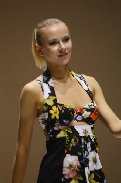 Moscow Traffic 5th International Exhibition of underwear, beachwear, home wear and hosiery Lingrie Expo Young blonde woman in a black bathing suit with roses — Zdjęcie stockowe