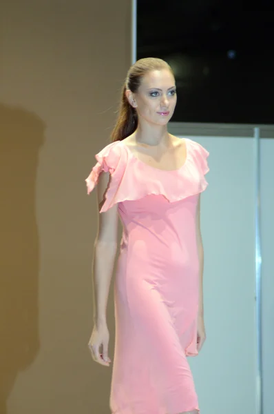 During the Show Lingrie Expo Moscow Autumn 5th International Exhibition of underwear, beachwear, home wear and hosiery Young brunette woman in pink negligee — Stockfoto