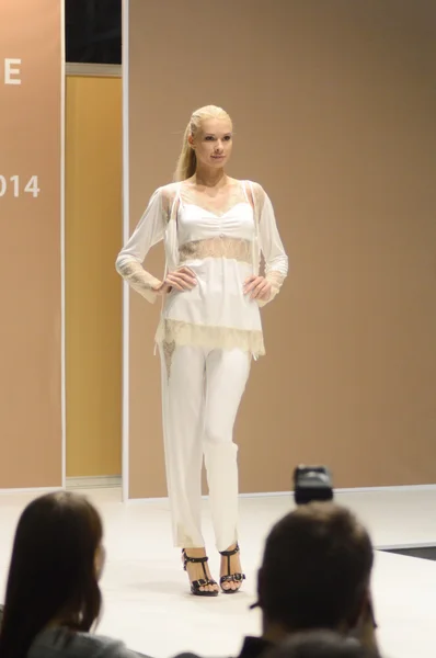 Young woman in white and yellow trouser suit night 5th International Exhibition of underwear... — Stockfoto