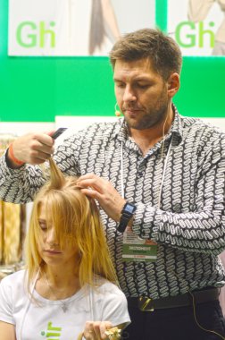 Trendy ana Kuaför şık kabarık genç sarışın bir kadın saç Show yapar