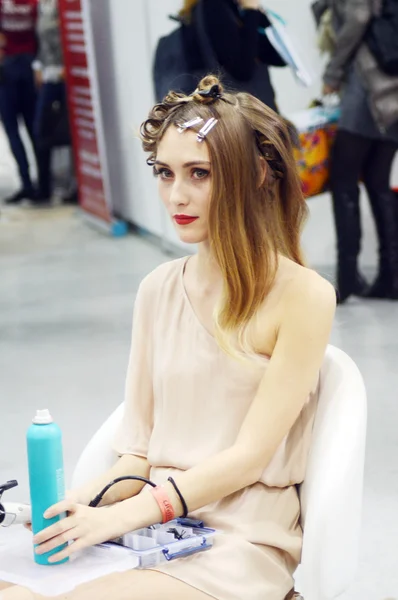 Intercharm XXI International Perfumery and Cosmetics Exhibition Young beautiful brunette girl with a new fashionable hairstyle. The curlers