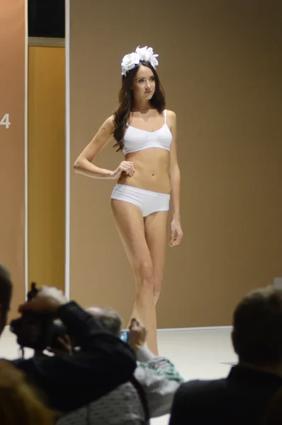 Moscow Traffic 5th International Exhibition of underwear, beachwear, home wear and hosiery Lingrie Expo Young beautiful brunette woman in a white bathing suit White roses — Zdjęcie stockowe