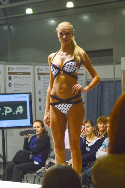 Moscow Traffic V Esposizione Internazionale di Biancheria intima, beachwear, home wear e calzetteria Lingrie Expo Giovane donna bionda in costume da bagno bianco e nero — Foto Stock