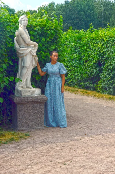 Giovane bella donna in abito blu in piedi accanto alla statua del Dio greco. Mosca. Grafici della fattoria Sheremetievs Kuskovo — Foto Stock