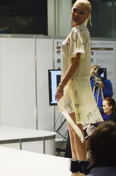 Moscow Traffic 5th International Exhibition of underwear, beachwear, home wear and hosiery Lingrie Expo Young blonde woman in a bathrobe lemon color — Stock Photo, Image