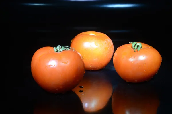 Pomidory (pomidory) na czarnym tle — Zdjęcie stockowe