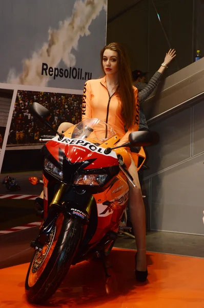 Moto Park 2015 Modelo morena bonita em um terno laranja montando uma motocicleta — Fotografia de Stock
