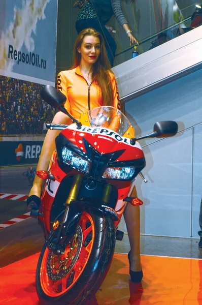 Moto Park 2015 Modelo morena bonita em um terno laranja montando uma motocicleta — Fotografia de Stock