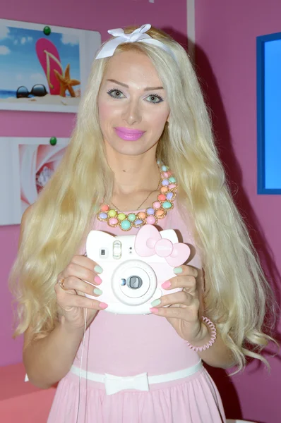 Young female model posing with a digital camera on a stand-known manufacturer of photographic equipment Photo Expo-2015. Moscow — Stock Photo, Image