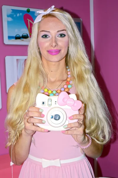 Young female model posing with a digital camera on a stand-known manufacturer of photographic equipment Photo Expo-2015. Moscow — Stock Photo, Image