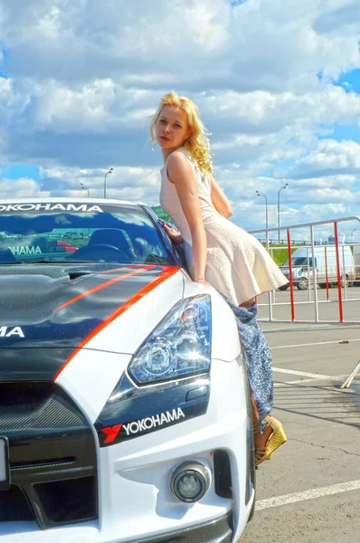 Jovem, bela mulher posando perto do Nissan GTR — Fotografia de Stock