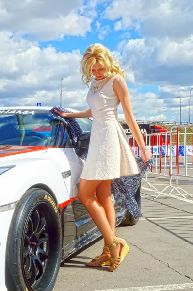 Young, beautiful woman posing near to the Nissan GTR — Stock Photo, Image