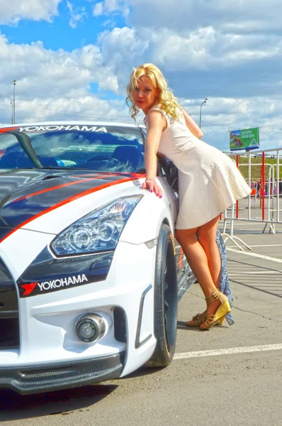 Jovem, bela mulher posando perto do Nissan GTR — Fotografia de Stock