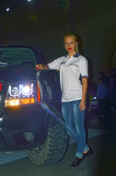 Moscow Tuning Show 2015. Uma menina participando da exposição posando ao lado de um SUV — Fotografia de Stock