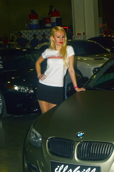 Moscow Tuning Show 2015. O modelo de beleza posando ao lado de um BMW cores metálicas — Fotografia de Stock