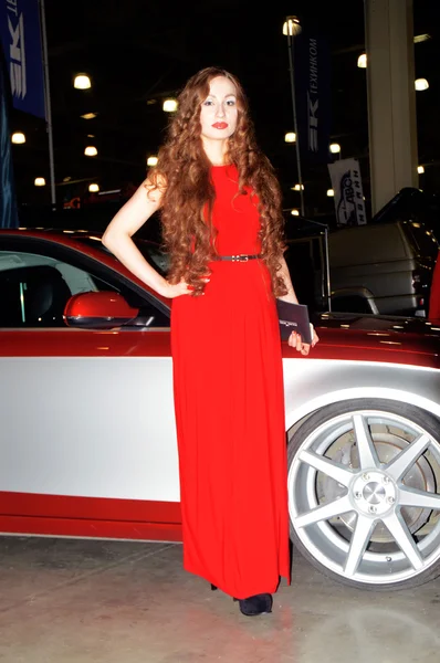 Moscow Tuning Show 2015. The girl model posing in red dress Sexy — Stock Photo, Image