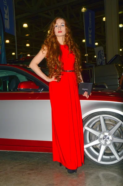 Московское тюнинг-шоу 2015. Девушка-модель, позирующая в красном платье — стоковое фото