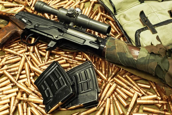Scharfschützengewehr mit Waffenhalter auf den losen Patronen — Stockfoto