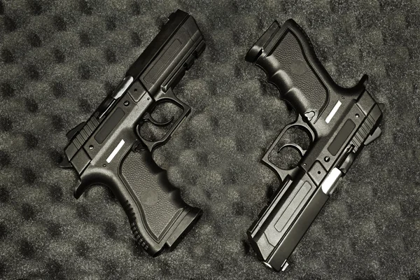 A fekete felületen két kézifegyver Stock Kép