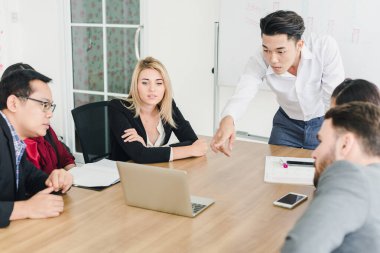 İş adamları, şirket toplantı odalarında problemleri çözmek için beyin fırtınası yapıyorlar..