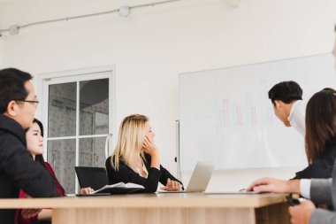 İş adamları, şirket toplantı odalarında problemleri çözmek için beyin fırtınası yapıyorlar..