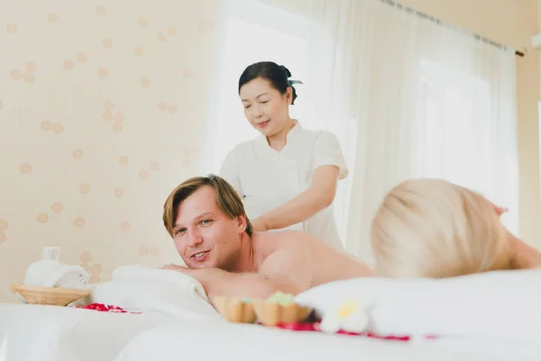 Young man doing a back massage. The female spa staff gave him a massage. For a relaxing feeling in the spa.