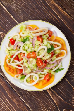 Mürekkep balığı, domates, soğan, yeşillik salatası.