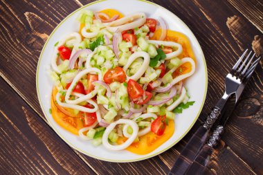 Mürekkep balığı, domates, soğan, yeşillik salatası.