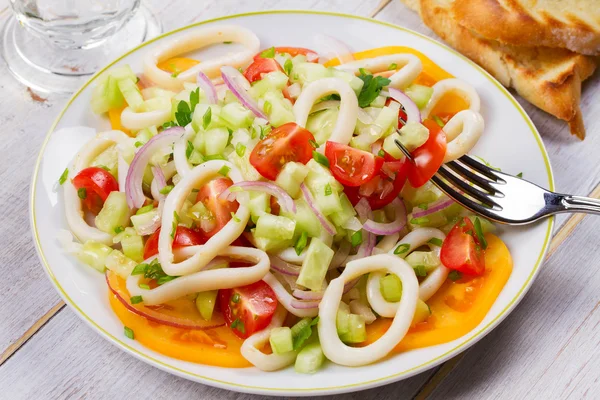 Squid, tomato, onion and greens salad. — Stock Photo, Image