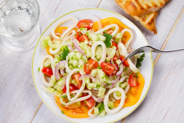 Squid, tomato, onion and greens salad. — Stock Photo, Image