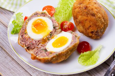 Viski yumurta domates kiraz ve beyaz tabakta salata ile servis