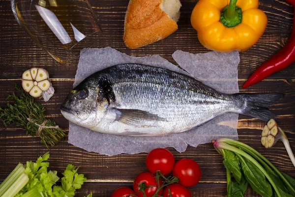 Overhead View of Dorado Fish, Spinach, Bell Pepper, Tomato Cherry, Bread, Garlic, Thyme, Olive Oil, Glass of White Wine and Celery on Dark Rustic Wooden Background — Stock Photo, Image