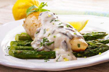 Kızarmış tavuk göğsü üzerinde kuşkonmaz tarhun ve mantar sos ile