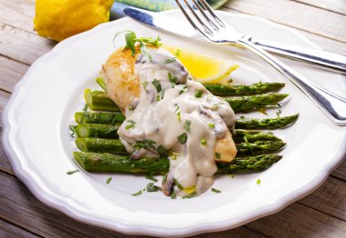 Kızarmış tavuk göğsü üzerinde kuşkonmaz tarhun ve mantar sos ile