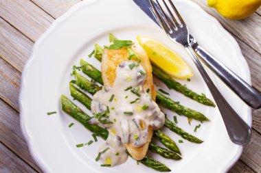 Kızarmış tavuk göğsü üzerinde kuşkonmaz tarhun ve mantar sos ile