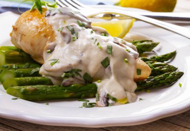 Kızarmış tavuk göğsü üzerinde kuşkonmaz tarhun ve mantar sos ile