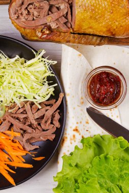 Ördek, havuç, lahana, salatalık, salata, domates sosu ve düz ekmek rendelenmiş. Malzemeler için rulo, sarar, burrito