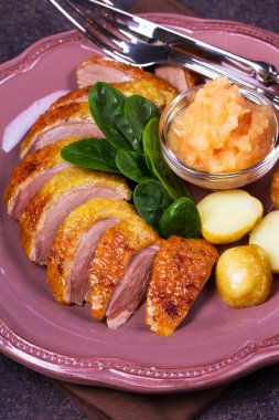 Ördek göğsü, elma sosu, ıspanak ve patates, pembe plaka üzerinde servis