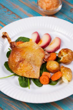 Ispanak, patates, elma sosu ve havuç mavi ahşap arka plan üzerinde ördek