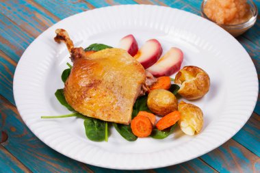 Ispanak, patates, elma sosu ve havuç mavi ahşap arka plan üzerinde ördek