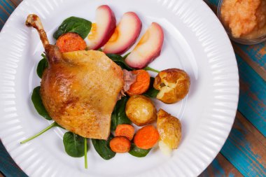 Ispanak, patates, elma sosu ve havuç mavi ahşap arka plan üzerinde ördek