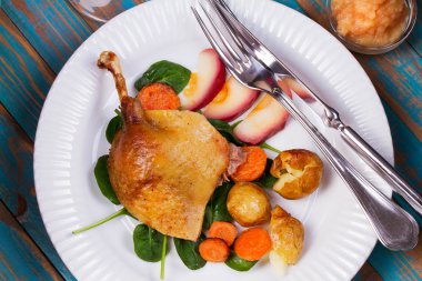 Ispanak, patates, elma sosu ve havuç mavi ahşap arka plan üzerinde ördek