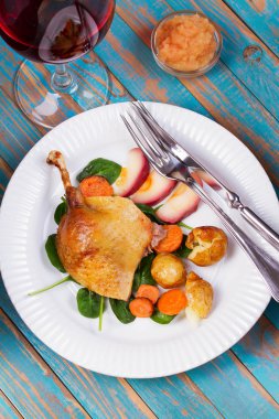 Ispanak, patates, elma sosu ve havuç mavi ahşap arka plan üzerinde ördek