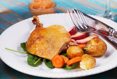 Ispanak, patates, elma sosu ve havuç mavi ahşap arka plan üzerinde ördek